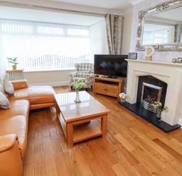 A living room with a sofa, coffee table, and television at Beach Cove View, Newbiggin-by-the-Sea