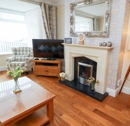A living room with a television and a fireplace at Beach Cove View in Newbiggin-by-the-Sea