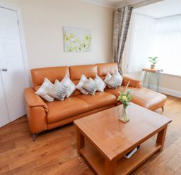 A living room with a sofa and a coffee table at Beach Cove View in Newbiggin-by-the-Sea