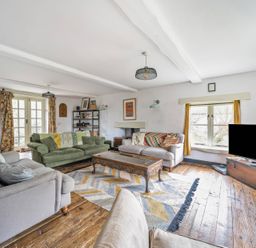 A living room with a sofa, coffee table, and television at Spring Park Farmhouse in Launceston