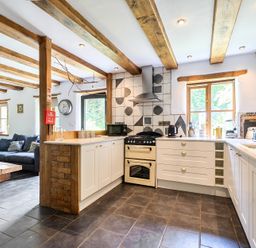 A kitchen with a cooker and shelving at Woodcutters in Rezare near Launceston