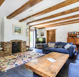 A living room with a fireplace and bookshelves at Woodcutters in Rezare near Launceston