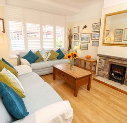 A living room with sofas, a coffee table, and a fireplace at 32 Cranleigh Close in Tuckton