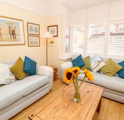 A living room with sofas and wall art at 32 Cranleigh Close Tuckton