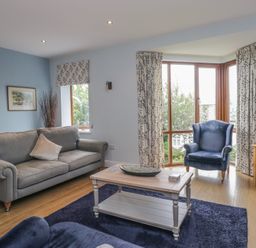 A living room with a sofa and armchair at Langtree in Arnside