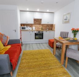A small living room with a sofa table and kitchenette at Bwlch Y Gwynt Bach in Llangefni