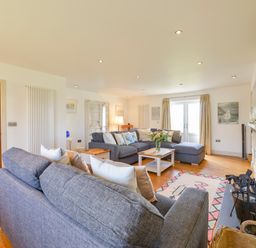 A living room with two grey sofas a coffee table a fireplace and wooden flooring at Duffield in St Ann's Chapel