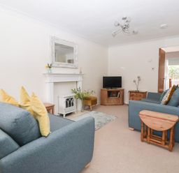A living room with a sofa, television, and coffee table at 17 Fewster Way York