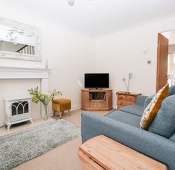 A living room with a sofa and television at 17 Fewster Way York
