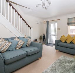 A living room with sofas and a staircase at 17 Fewster Way in York