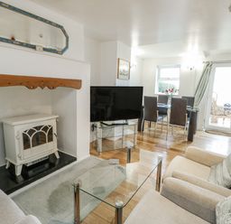 A living room with a fireplace and television at Preswylfa Apartment in Caernarfon