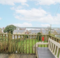 A garden with a view of houses and greenery at Preswylfa Apartment in Caernarfon