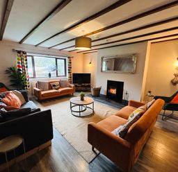 A living room with a fireplace and sofa arrangements at Stiniog Lodge in Blaenau Ffestiniog