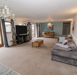 A living room with sofas a coffee table a television and glass doors at Shatterford Lakes in Shatterford