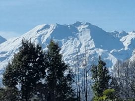 A view of snow-capped mountains and trees at Kune Crib - Ohakune Holiday Home near Turoa Ohakune