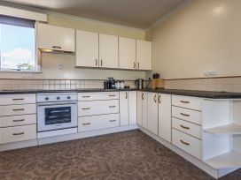 A kitchen with cabinets countertop and oven at Kune Crib - Ohakune Holiday Home near Turoa