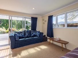 A living room with a sofa and table at Kune Crib - Ohakune Holiday Home near Turoa