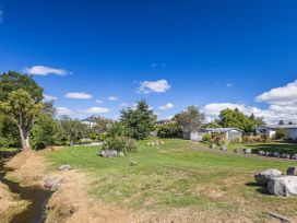 An outdoor area with grass and trees at Kune Crib - Ohakune Holiday Home near Turoa in Ohakune