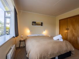A bedroom with a bed and nightstand at Kune Crib - Ohakune Holiday Home near Turoa