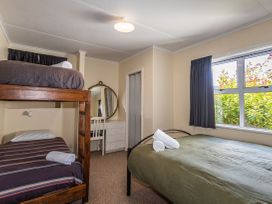 A bedroom with a bunk bed and a double bed at Kune Crib - Ohakune Holiday Home near Turoa