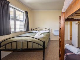 A bedroom with a double bed and bunk bed at Kune Crib - Ohakune Holiday Home near Turoa