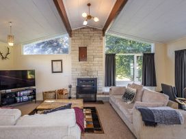 A living room with a sofa and television at Kune Crib - Ohakune Holiday Home near Turoa