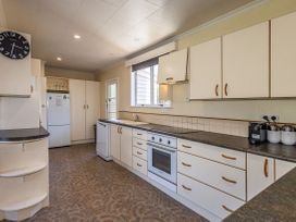 A kitchen featuring appliances and fixtures at Kune Crib - Ohakune Holiday Home near Turoa