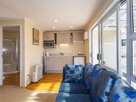 A living room with a sofa and kitchen unit at Kune Crib - Ohakune Holiday Home near Turoa
