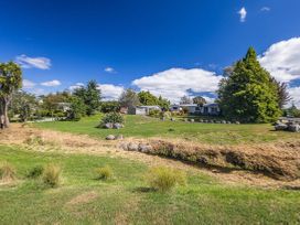 A grassy area with trees and a house at Kune Crib - Ohakune Holiday Home near Turoa, Ohakune