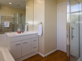 A bathroom with a sink, shower stall, and towel rack at Kune Crib - Ohakune Holiday Home near Turoa
