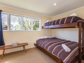 A bedroom with a bunk bed and double bed at Kune Crib - Ohakune Holiday Home near Turoa
