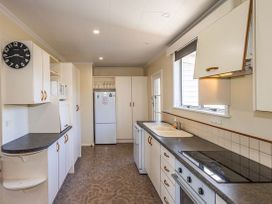 A kitchen with a sink and stove at Kune Crib - Ohakune Holiday Home near Turoa