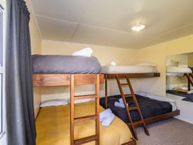 A bedroom with bunk beds and a mirror at Kune Crib - Ohakune Holiday Home near Turoa in Ohakune