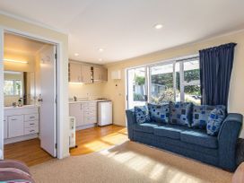 A living room with a sofa and kitchen area at Kune Crib - Ohakune Holiday Home near Turoa