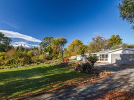A house with a driveway and trees in the foreground at Kune Crib - Ohakune Holiday Home near Turoa, Ohakune