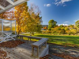 An outdoor area with a bench and table near trees at Kune Crib - Ohakune