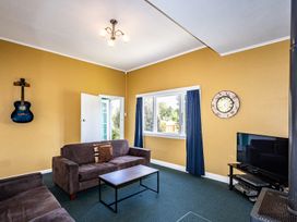 A living room with furniture and a guitar at Oroua Cottage - Rangataua Bach Ohakune