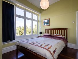 A bedroom with a bed and a window at Oroua Cottage - Rangataua Bach in Ohakune