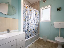 A bathroom with a sink, toilet and shower at Oroua Cottage - Rangataua Bach Ohakune