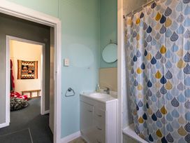 A bathroom with a sink and shower curtain at Oroua Cottage - Rangataua Bach in Ohakune