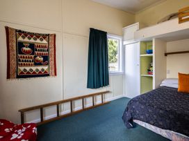 A bedroom featuring a bed and window at Oroua Cottage - Rangataua Bach in Ohakune