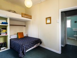 A bedroom with a bed and shelf at Oroua Cottage - Rangataua Bach Ohakune