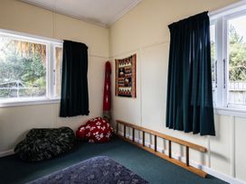 A bedroom with bean bags and a wall hanging at Oroua Cottage - Rangataua Bach in Ohakune