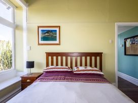 A bedroom with a bed and a lamp at Oroua Cottage - Rangataua Bach Ohakune