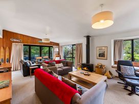 A living room with a fireplace and seating area at Pukawa Haven - Pukawa Bay