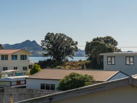 A view of houses and water with mountains in the background at Joes Place - Cooks Beach