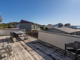 An outdoor area with a table and chairs at Joes Place - Cooks Beach Holiday Home, Cooks Beach