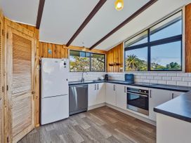 A kitchen with refrigerator and oven at Joes Place - Cooks Beach Holiday Home Cooks Beach