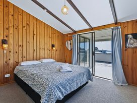 A bedroom with wood paneling and a bed at Joes Place - Cooks Beach Holiday Home Cooks Beach