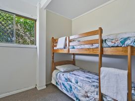 A bedroom with a bunk bed and a window at Joes Place - Cooks Beach Holiday Home Cooks Beach